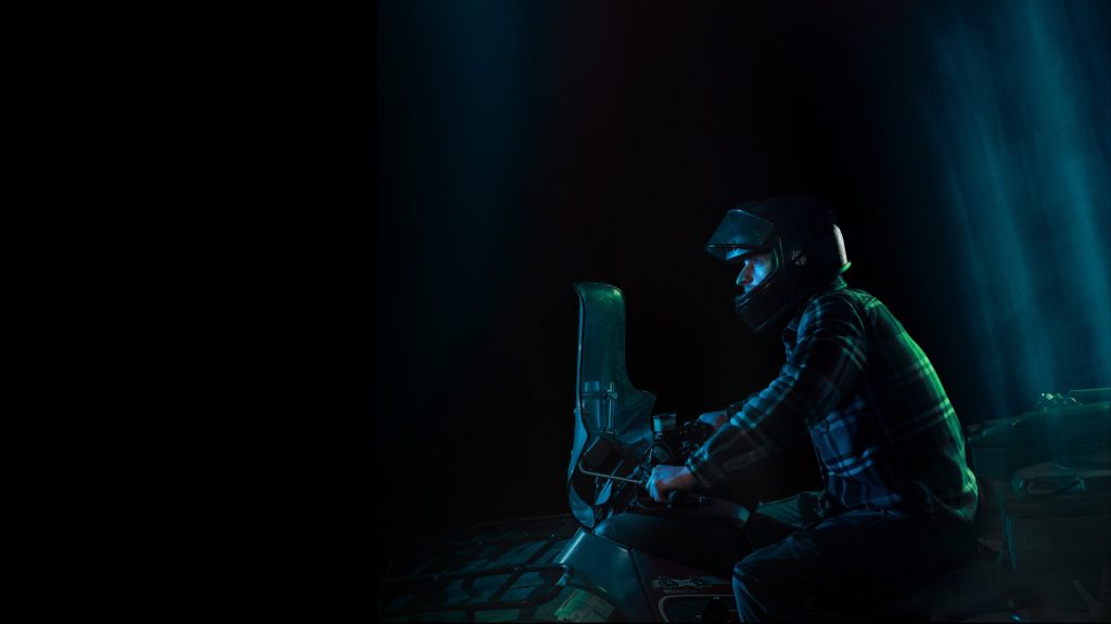 Helmeted off-road rider at night, from the Your World Could Change in a Split Second campaign.