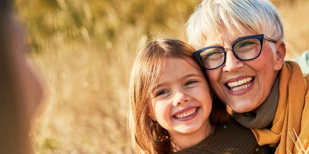 Older adult and child smiling together, from the Fall Talk prevention campaign.